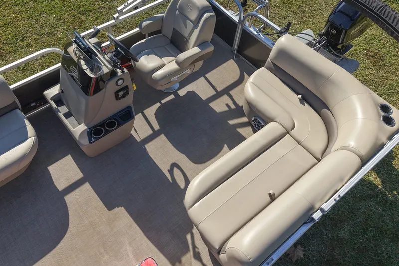 Slide: The Image of 2025 Sun Tracker Party Barge 16 DLX interior with beige seating and steering console. - 7