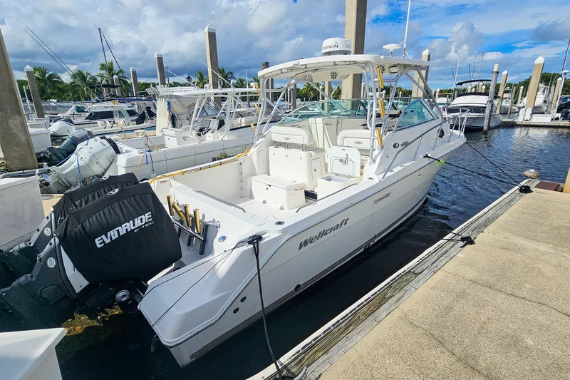 Slide: The Image of 2005 Wellcraft 290 Coastal boat docked at marina with Evinrude engines. - 10