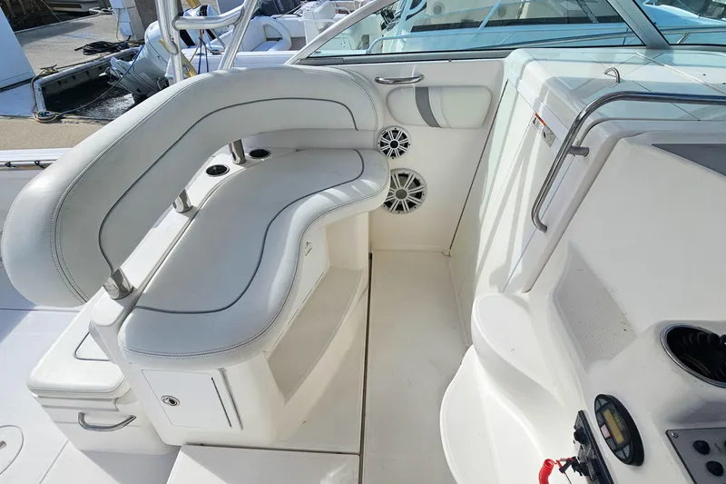Slide: The Image of 2005 Wellcraft 290 Coastal boat interior with white seating and speakers. - 12