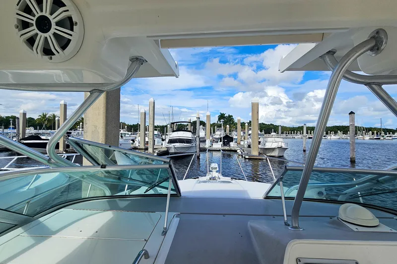 Slide: The Image of 2005 Wellcraft 290 Coastal boat docked at marina, clear sky, and calm waters. - 13