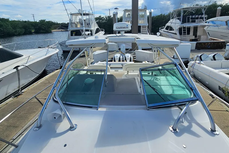 Slide: The Image of 2005 Wellcraft 290 Coastal boat docked, featuring a Garmin radar and spacious deck. - 15