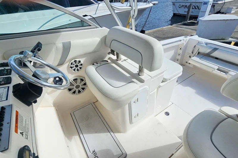 Slide: The Image of 2005 Wellcraft 290 Coastal boat interior with steering wheel and white seating. - 16