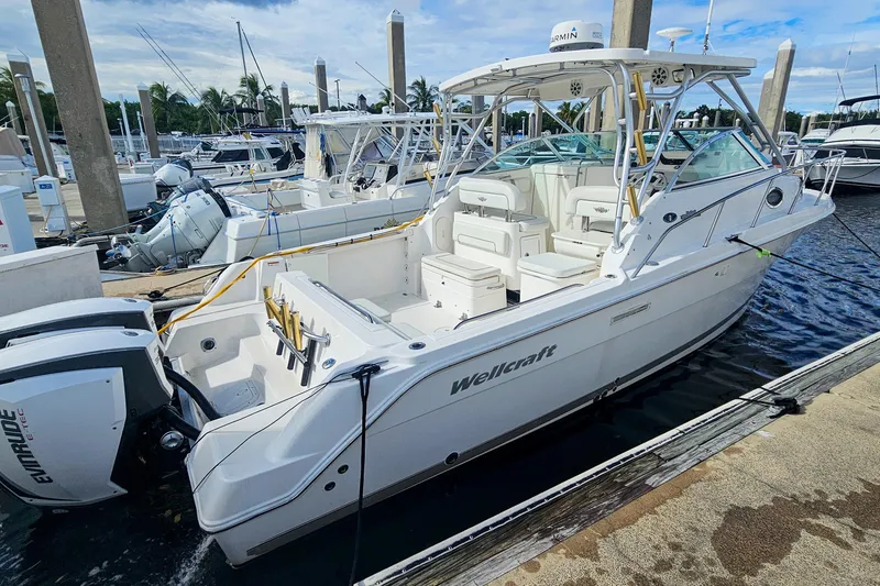 Slide: The Image of 2005 Wellcraft 290 Coastal boat docked at marina with Evinrude engines. - 18