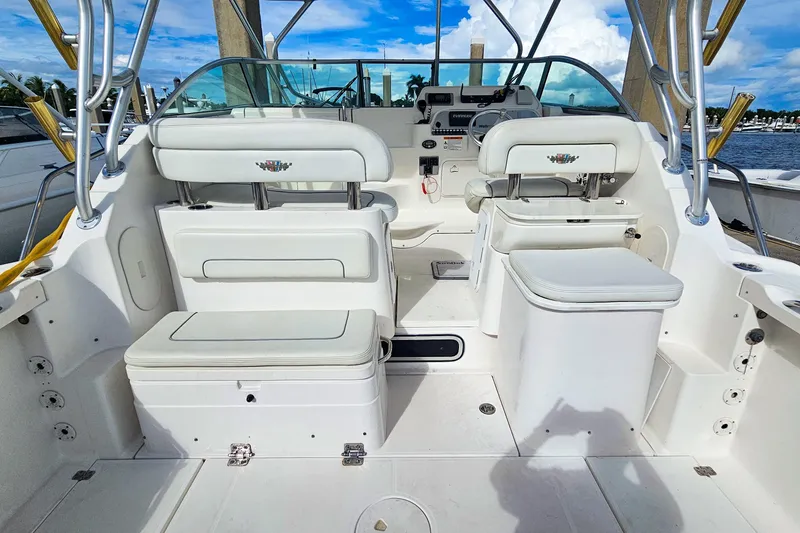 Slide: The Image of 2005 Wellcraft 290 Coastal boat interior with seating and control panel, docked by the water. - 23