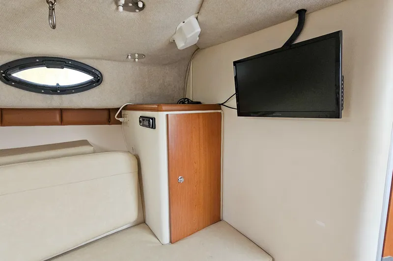 Slide: The Image of 2005 Wellcraft 290 Coastal cabin interior with TV and storage cabinet. - 28