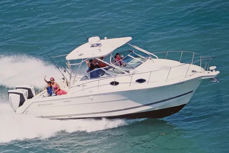 Slide: The Image of 2005 Wellcraft 290 Coastal boat cruising on blue ocean with passengers enjoying the ride. - 3