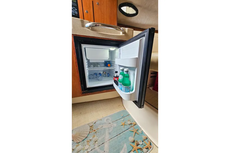 Slide: The Image of Open mini fridge inside 2005 Wellcraft 290 Coastal boat cabin, stocked with drinks. - 31