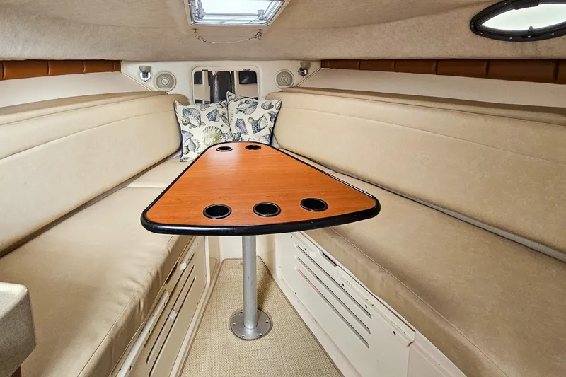 Slide: The Image of 2005 Wellcraft 290 Coastal cabin interior with beige seating and wooden table. - 32