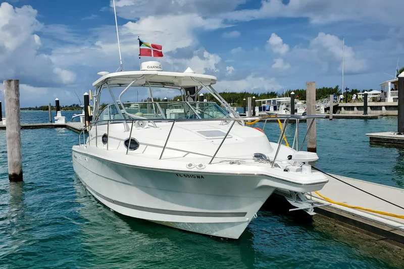 Slide: The Image of 2005 Wellcraft 290 Coastal boat docked in a marina under a cloudy sky. - 8