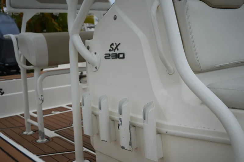 Slide: The Image of 2017 Skeeter SX230 boat interior with white seating and rod holders. - 10