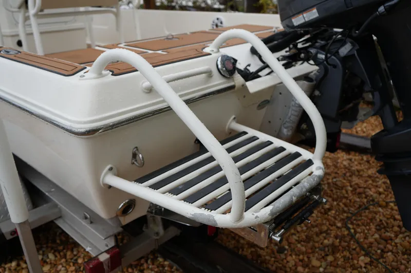 Slide: The Image of 2017 Skeeter SX230 boat with swim platform and motor, on a gravel surface. - 19