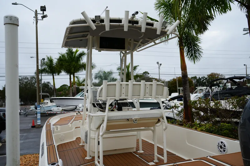 Slide: The Image of 2017 Skeeter SX230 boat with T-top and seating, displayed outdoors near palm trees. - 22