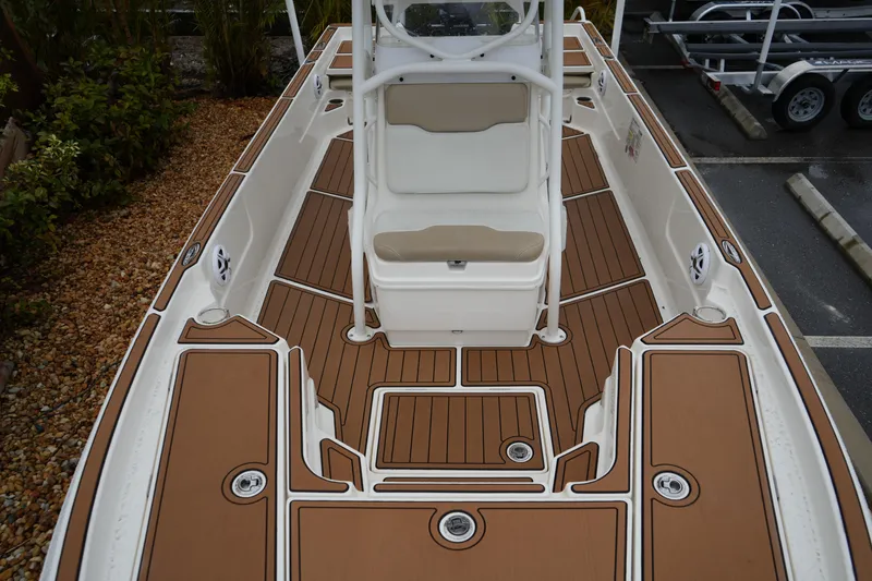 Slide: The Image of 2017 Skeeter SX230 boat interior with brown deck and white seating. - 34
