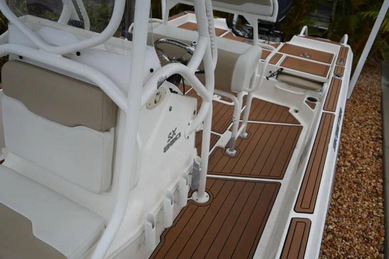 Slide: The Image of 2017 Skeeter SX230 boat interior with white seating and wood-patterned flooring. - 35