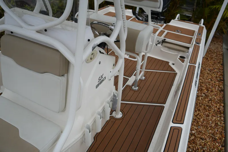 Slide: The Image of 2017 Skeeter SX230 boat interior with brown deck and white seating. - 36
