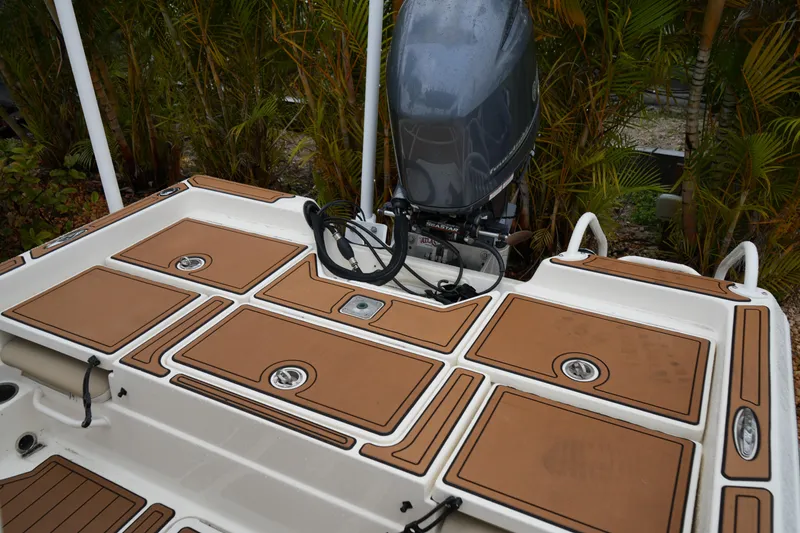 Slide: The Image of 2017 Skeeter SX230 boat deck with outboard motor, surrounded by lush greenery. - 40