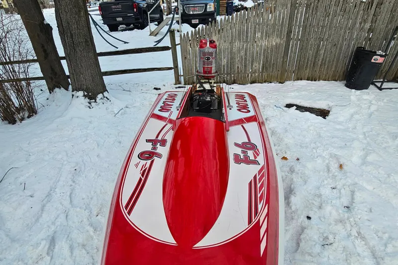Slide: The Image of 1987 De Silva F Class Race boat in snowy yard, red and white design. - 7