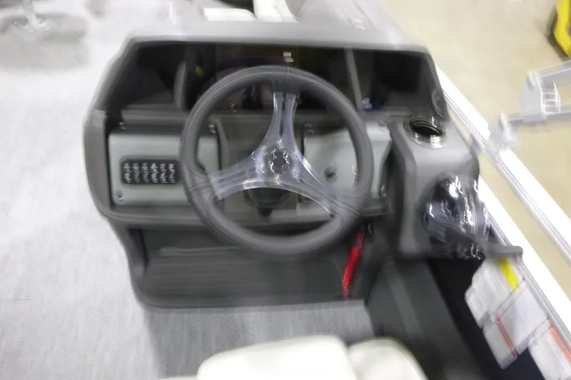 Slide: The Image of Blurry view of 2026 Sun Tracker Fishin' Barge 22 DLX steering console. - 14