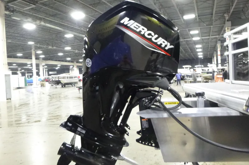 Slide: The Image of 2026 Sun Tracker Fishin' Barge 22 DLX with Mercury outboard motor in a showroom. - 18
