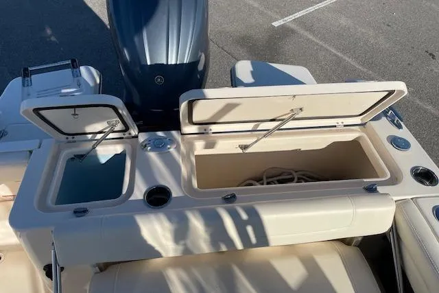 Slide: The Image of 2022 Grady-White Freedom 235 boat with open storage compartments and engine view. - 10