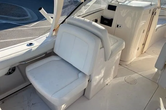 Slide: The Image of 2022 Grady-White Freedom 235 boat interior with white seating and helm station. - 11