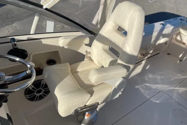 Slide: The Image of 2022 Grady-White Freedom 235 boat interior with white captain's chair and steering wheel. - 13