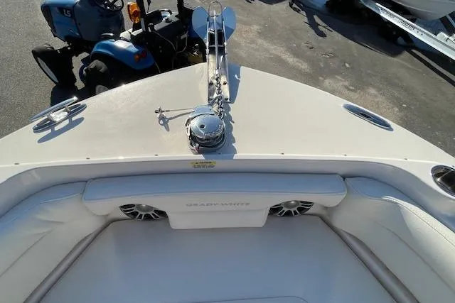 Slide: The Image of 2022 Grady-White Freedom 235 boat bow with seating and anchor, parked near a tractor. - 20