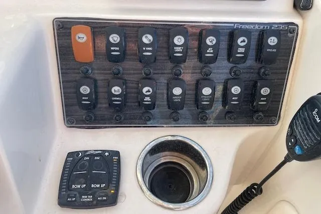 Slide: The Image of Control panel of 2022 Grady-White Freedom 235 boat with various switches and microphone. - 26