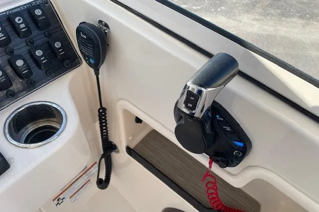 Slide: The Image of Control panel of 2022 Grady-White Freedom 235 boat with throttle and radio. - 27