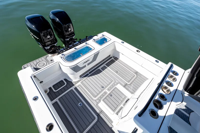 Slide: The Image of 2022 Invincible 33 Open Fisherman boat deck with twin engines on calm water. - 17