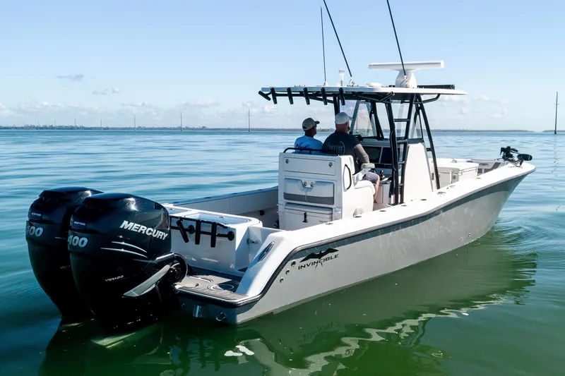 Slide: The Image of 2022 Invincible 33 Open Fisherman boat with dual Mercury engines on calm water. - 2