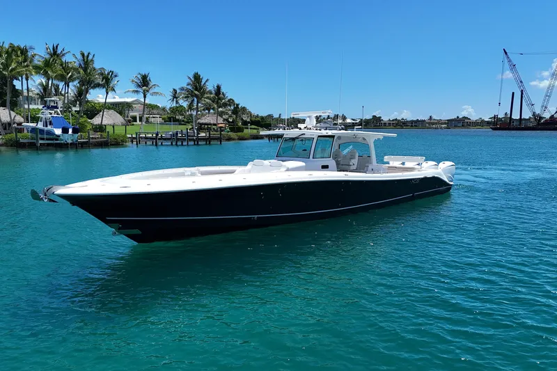 Slide: The Image of 2020 HCB 53 Sueños boat cruising on clear blue water near palm trees. - 1
