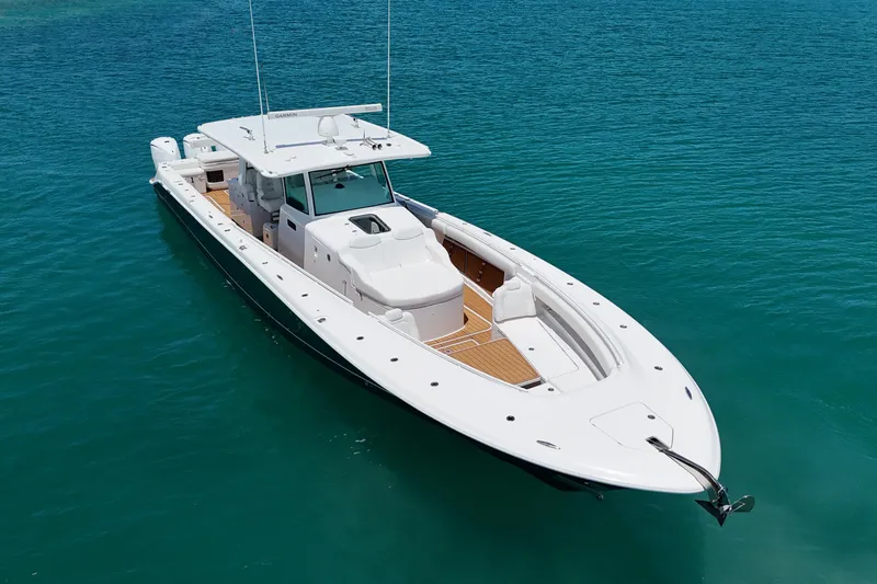 Slide: The Image of 2020 HCB 53 Sueños boat on clear blue water, showcasing sleek design and spacious deck. - 12