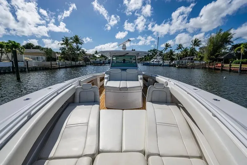 Slide: The Image of 2020 HCB 53 Sueños luxury boat with spacious seating, cruising on a sunny waterway. - 15