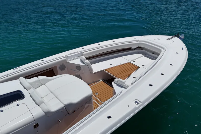 Slide: The Image of 2020 HCB 53 Sueños boat with sleek white deck and wooden accents on blue water. - 13