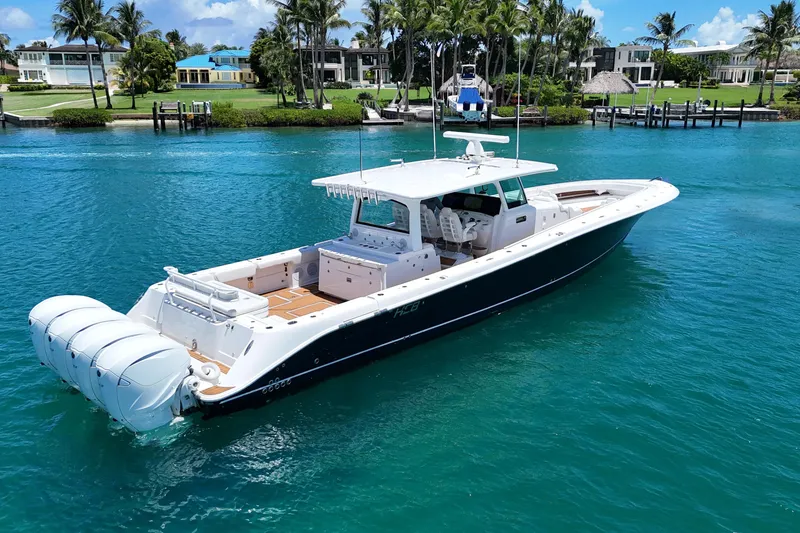 Slide: The Image of 2020 HCB 53 Sueños luxury boat on clear blue water, surrounded by palm trees. - 4