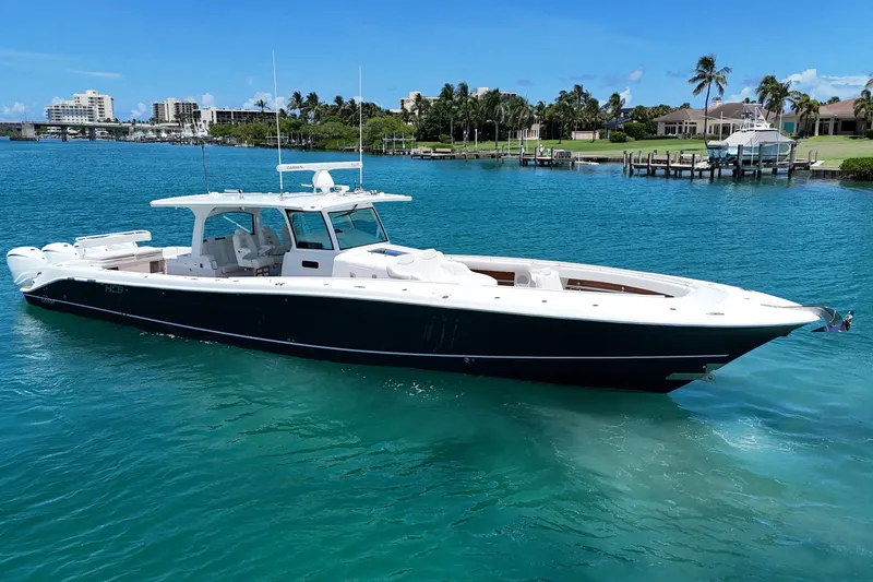Slide: The Image of 2020 HCB 53 Sueños luxury boat on clear blue water, near a tropical shoreline. - 7