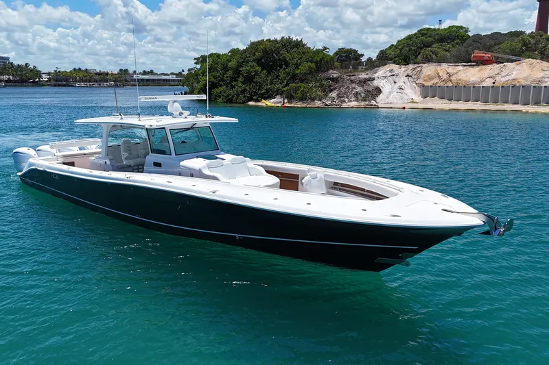 Slide: The Image of 2020 HCB 53 Sueños boat on clear blue water near a sandy shore. - 8