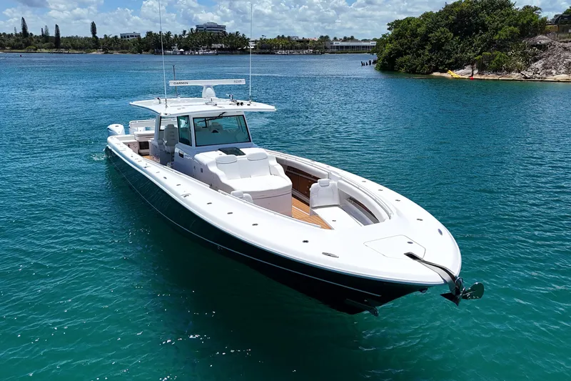 Slide: The Image of 2020 HCB 53 Sueños boat on clear blue water, near a lush shoreline. - 9