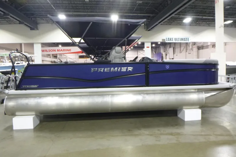 The Image of 2026 Premier 220 SUNSCAPE RL pontoon boat displayed indoors at a marine showroom. - 1