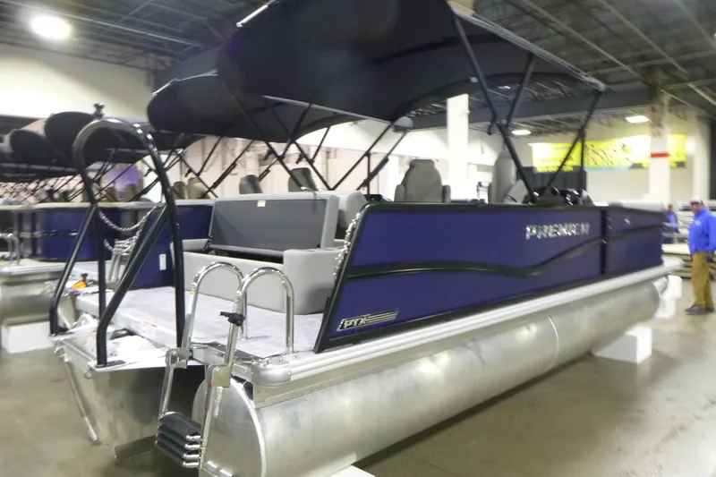 Slide: The Image of 2026 Premier 220 SUNSCAPE RL pontoon boat displayed indoors with canopy. - 2