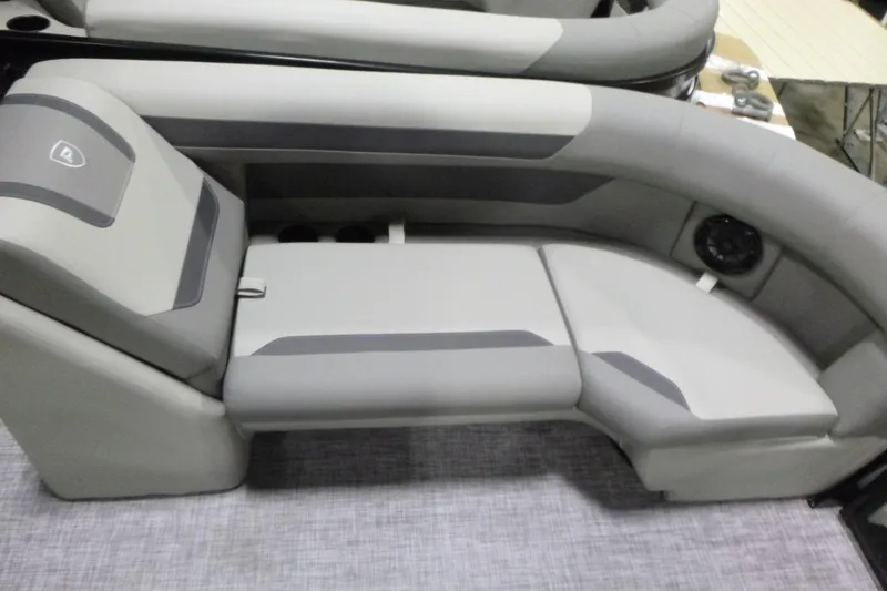 Slide: The Image of Gray seating area on 2026 Premier 220 SUNSCAPE RL boat, featuring modern design and integrated speaker. - 9