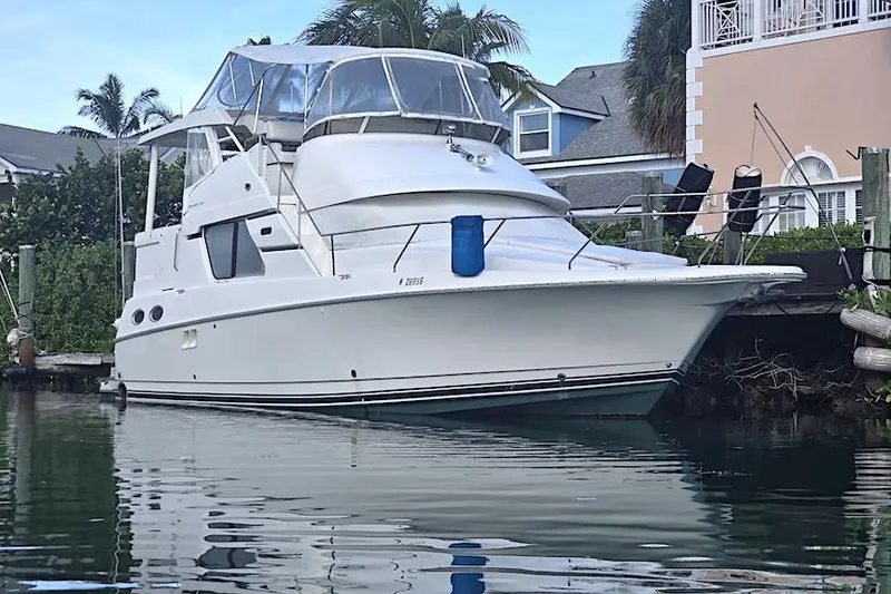 The Image of 2000 Silverton 392 Motor Yacht docked near waterfront homes. - 0