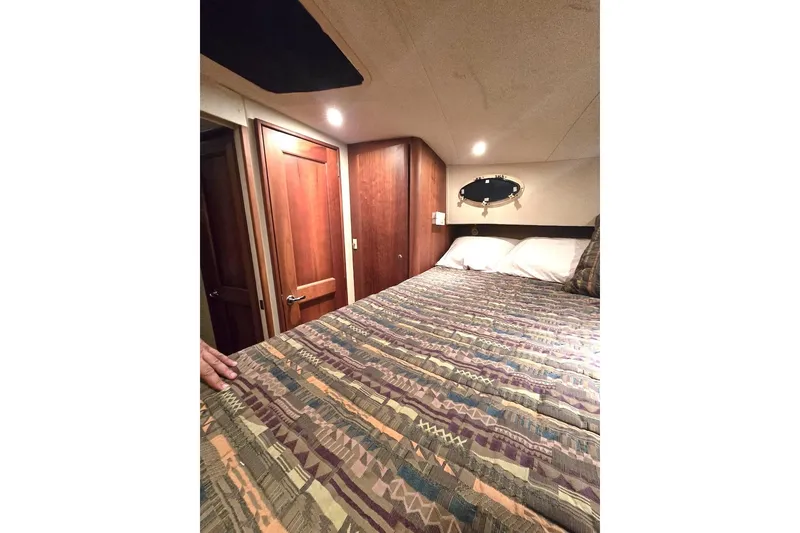 Slide: The Image of Interior of 2000 Silverton 392 Motor Yacht with cozy bed and wooden cabinetry. - 2