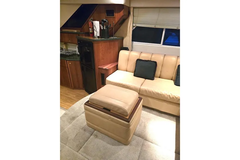 Slide: The Image of Interior of 2000 Silverton 392 Motor Yacht with beige sofa and compact kitchen area. - 5