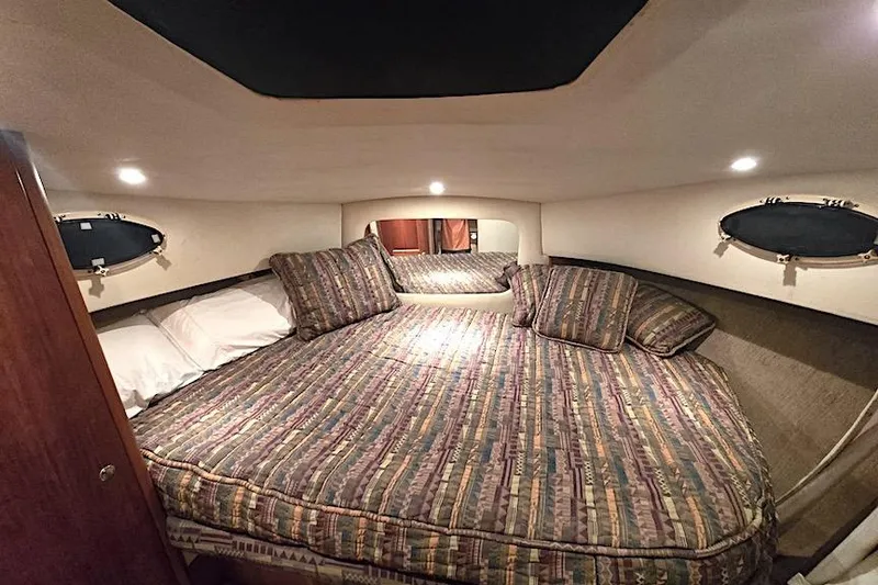 Slide: The Image of Cozy bedroom interior of 2000 Silverton 392 Motor Yacht with patterned bedding and soft lighting. - 8