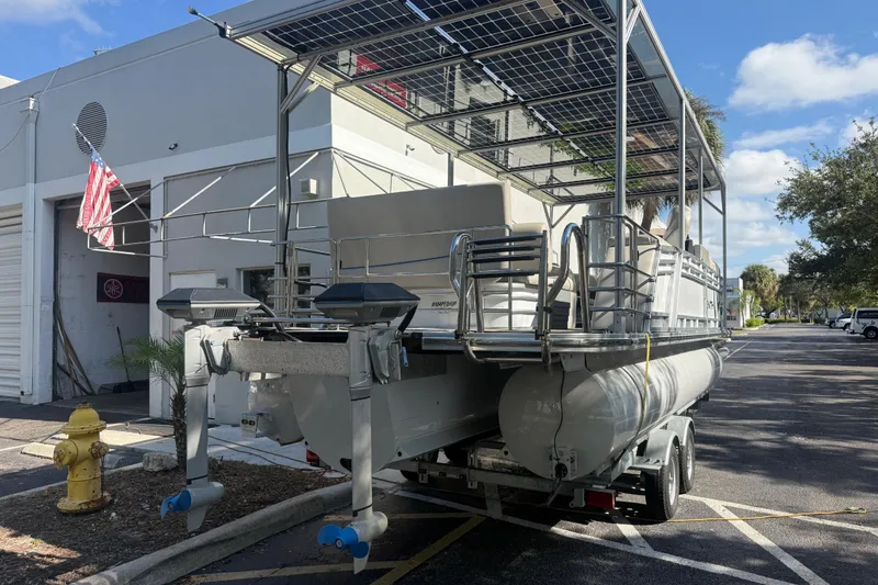 Slide: The Image of 2023 Starcraft SLS 3 Q DH pontoon boat on trailer, parked near a building. - 15