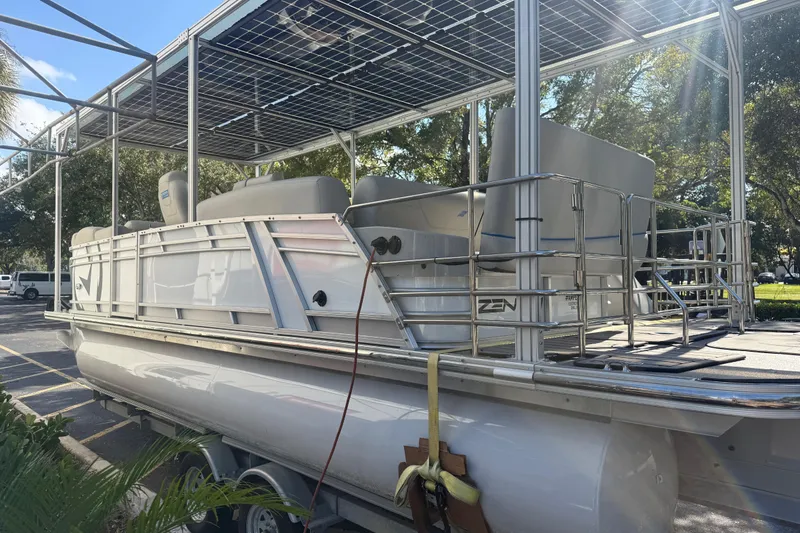 Slide: The Image of 2023 Starcraft SLS 3 Q DH pontoon boat with solar panels, parked outdoors. - 16