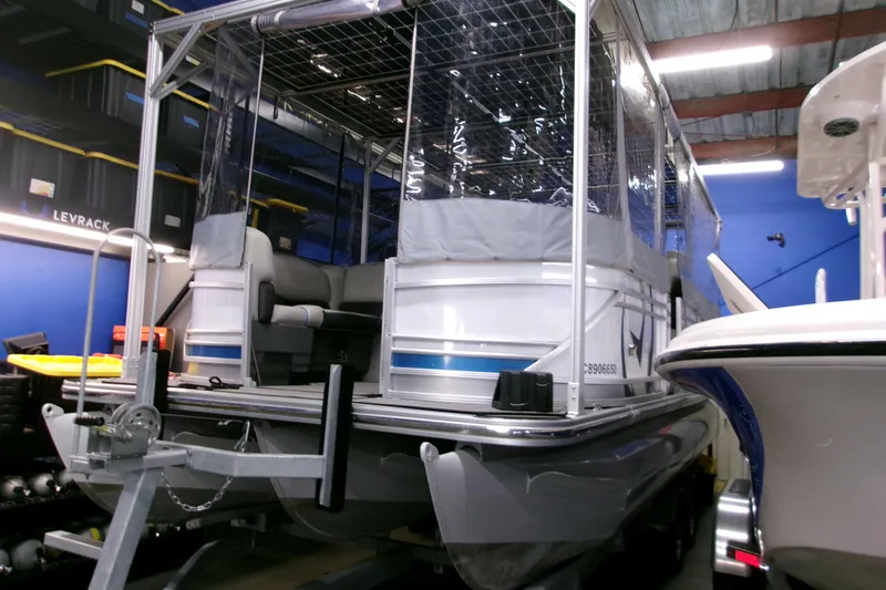 Slide: The Image of 2023 Starcraft SLS 3 Q DH pontoon boat in a storage facility. - 2
