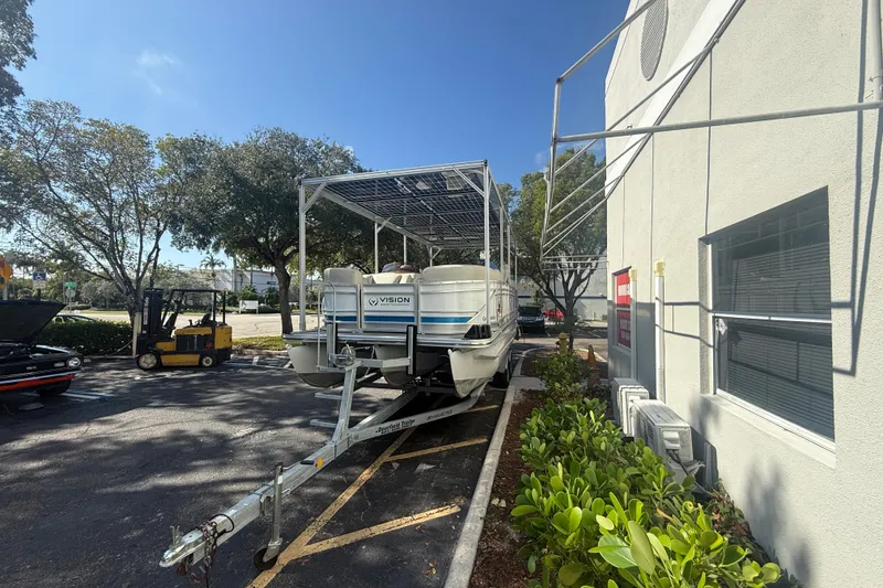 Slide: The Image of 2023 Starcraft SLS 3 Q DH boat on trailer, parked beside building under clear sky. - 27